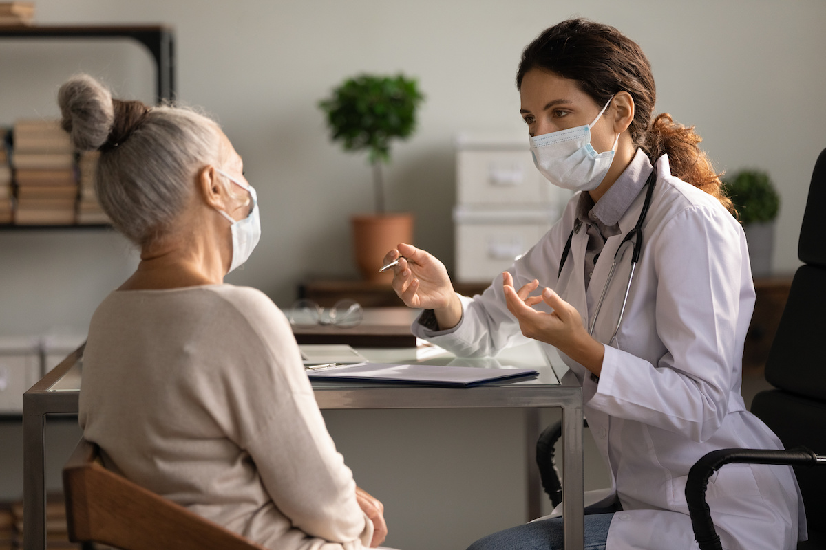 Conversation between doctor and patient who are wearing masks