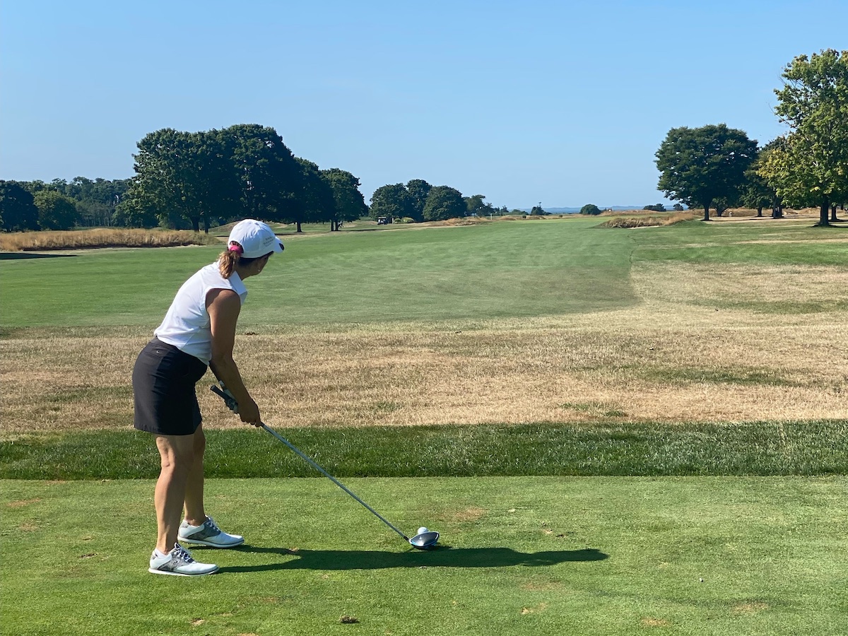 Anne Marie driving a golf ball on a golf course